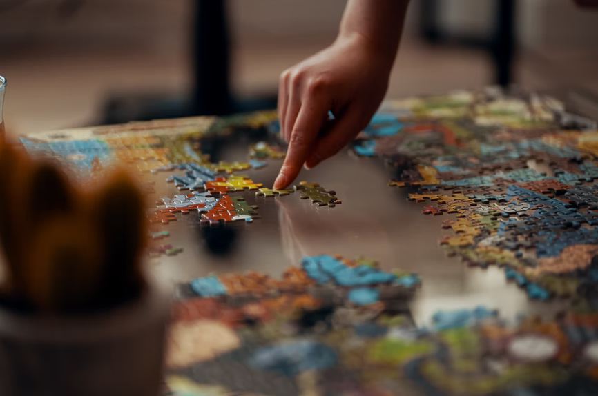 Picture of a person playing puzzles with a detailed outlook as every piece seems separate.