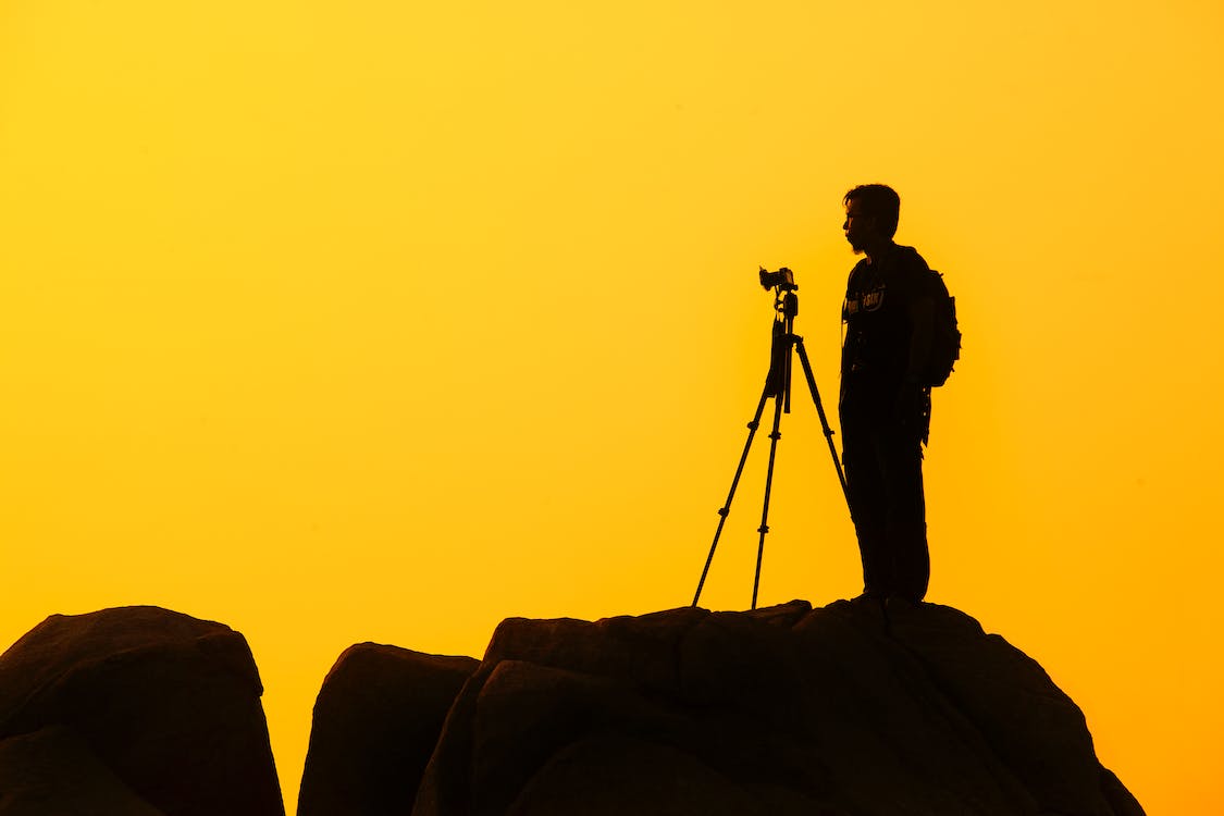 man standing on rock formation preparing for a shoot
