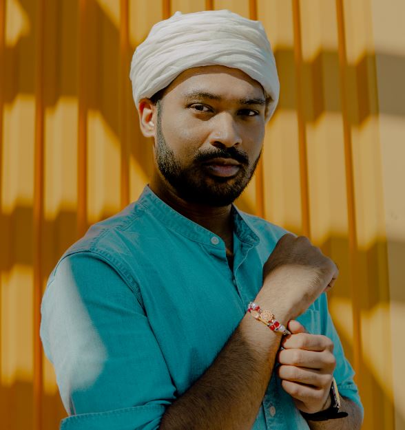 man in turban standing beside yellow wall