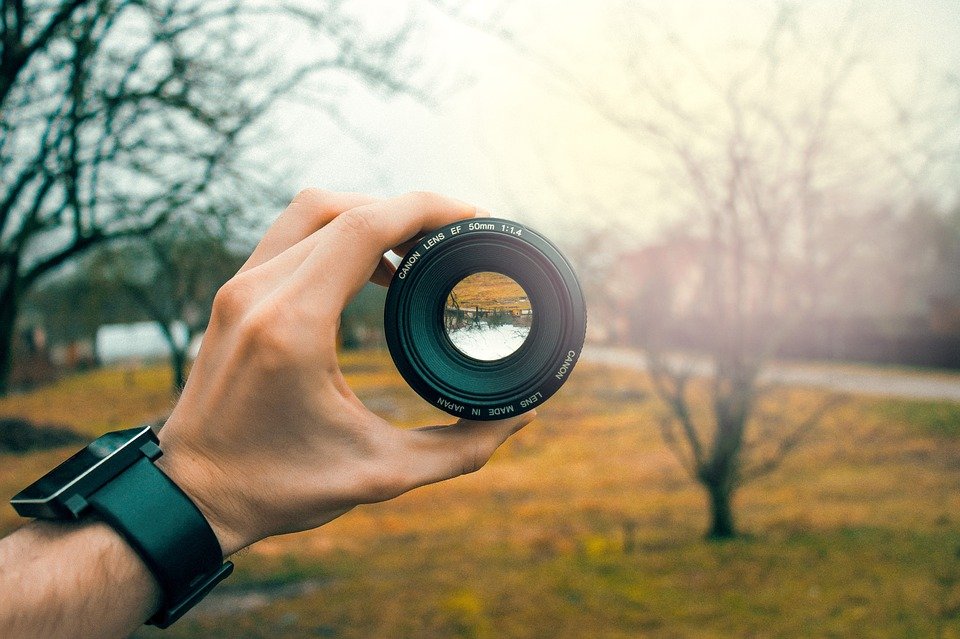 Person holding a lens