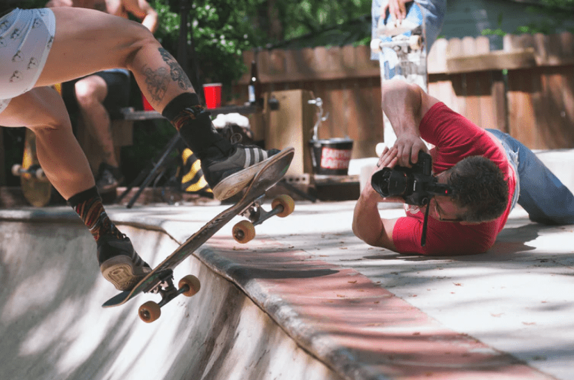 A photographer clicking a photo of a skateboarder
