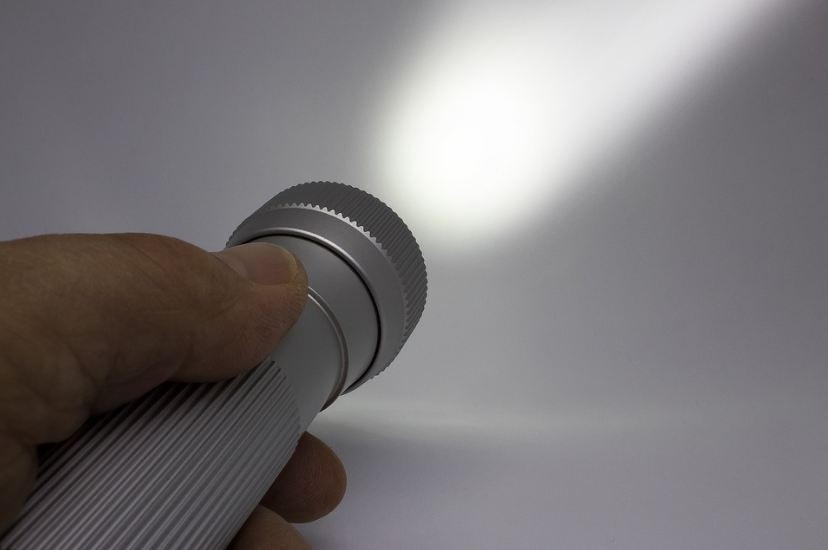 Image of a person holding a flashlight in their hand.