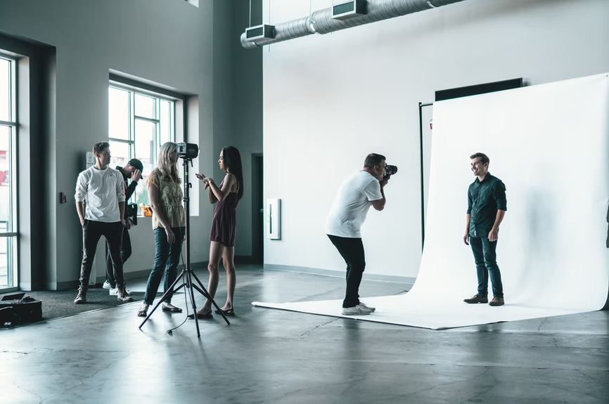a photographer taking a model’s photo in a studio