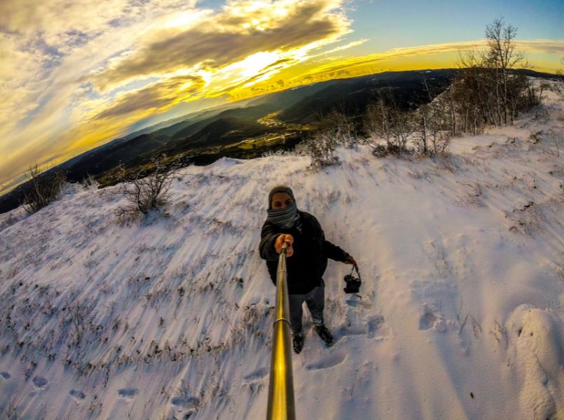Taking a selfie in a snowy terrain using a selfie stick